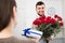 Positive young guy presented bouquet and gift