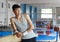 Positive young man asian acrobat posing at modern sport gym