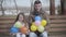 Positive young man and little girl moving down colorful balloons and smiling at camera. Cheerful Caucasian daughter and