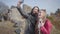 Positive young man and woman making selfie in autumn park. Guy with long curly black hair and blond pretty girl looking