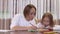 Positive young woman is drawing with her little beautiful daughter