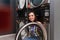 Positive young woman sitting on the dryer machine in the self-service laundromat