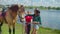 Positive young women preparing horse for riding