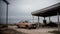 Post-apocalyptic abandoned gas station and rusty cars, desolate landscape. Generative AI