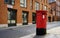 post box in london street with red houses