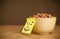 Post-it note with smiley face sticked on a cereal bowl