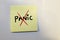 Post-it note with the text panic covered by a cross.