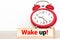 Post it word wake up alarm clock on wood desk white background