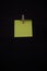 Post it yellow fluorescent with wooden clip with black background copy space annotation remember for text