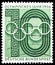 Postage stamp printed in Germany shows Olympic rings over numeral, Olympic year serie, circa 1956