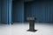 A postament on the empty stage with blue curtains and concrete floor, standup and speech concep. 3d rendering