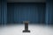 A postament on the empty stage with blue curtains and concrete floor, standup and speech concept. 3d rendering, mock up