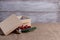 postcard from beige gift box with open lid and sprig of Christmas tree with decorations on wooden background and burlap