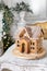 Postcard gingerbread house. Defocused lights of Christmas tree. Holiday mood. Christmas and Happy new year.