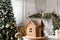 Postcard gingerbread house. Defocused lights of Christmas tree. Holiday mood. Christmas and Happy new year.