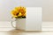 Postcard mockup with white cup and sunflowers. Empty card and enamel cup with space for text or print. White background