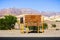 Posted road directions and distances close to the Furnace Creek Visitor Center; desert and mountains landscape in the background;