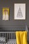 Poster above child`s bed with yellow blanket in grey bedroom int