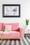 Poster above pink couch in modern living room interior with plan