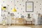Poster in a black frame on a white wall with stickers in a scandinavian style child bedroom interior with wooden furniture and ye