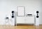 Poster Frame Mockup in white modern interior. Modern audio stereo system with white speakers on bureau in modern interior.