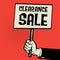 Poster in hand, business concept with text Clearance Sale