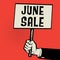 Poster in hand, business concept with text June Sale