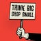 Poster in hand, business concept with text Think Big, Shop Small