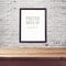 Poster mock up template with wooden table over brick white wall