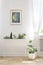 Poster on white wall above plants in living room interior with d