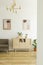 Posters on a white wall, comfy sofa and a simple, wooden cabinet