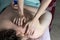 A postpartum doula gives a woman a manual back massage.