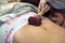 Postpartum doula shows how to massage a cesarean scar with a Lyapko applicator.