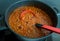 A pot of chilli beef soup with red beans, cooking on a stove