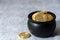 Pot of gold bitcoins on a white and gray crackle background, one coin on background