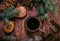 Pot of hot herbal tea, fir cones and paws of blue fir on wooden background