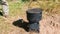 Pot on a metal camp furnace stove on woods outdoors. Close-up.