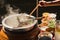 .The pot is prepared for cooking. The noodles are in low-light, boiling water with white smoke and steam on black background