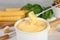Pot of tasty cheese fondue and products on white table, closeup view