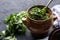 A pot with vats of greens and a towel on a dark background