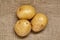 Potato on black wood table in kitchen. Preperation for cooking.