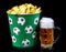 Potato chips in a classic bucket and a glass of beer isolated on a black background.