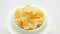 Potato chips heap rotating on a white plate