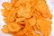 potato chips sliced and cutout in thin layers and fried in oil, pile of tomato flavored potatoes\' chips in a plate