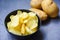 Potato chips snack on bowl, Crispy potato chips on the kitchen table and fresh raw potatoes on dark background