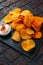 Potato chips, snack crisps with red paprika and white dip sauce