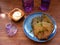 Potato flapjack draniki with sour cream and violet glass on wooden table