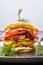 Potato fritter burger with chicken breast, bacon, cucumber and tomato