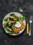 Potato latkes with baked apples, spinach salad on a dark background, top view. Delicious breakfast, snack, vegetarian lunch