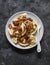 Potato pierogi with fried bacon and onions - delicious homemade lunch on a dark background, top view